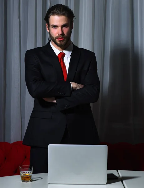 Barbudo, hombre de negocios con vaso de whisky, teléfono celular, portátil — Foto de Stock