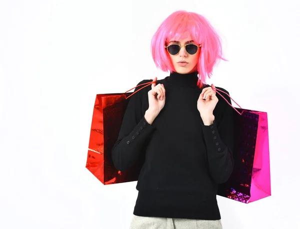 분홍색 가발을 쓴 유행하는 섹시 한 여자가 패키지나 가방을 들고 있다 — 스톡 사진
