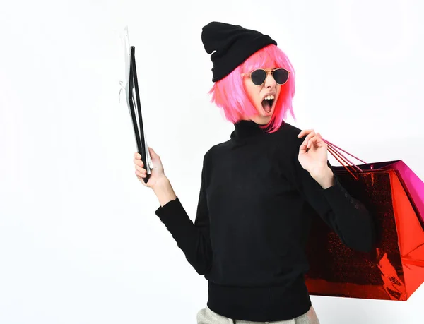 Menina sexy na moda em rosa peruca segurando pacote com cabides — Fotografia de Stock