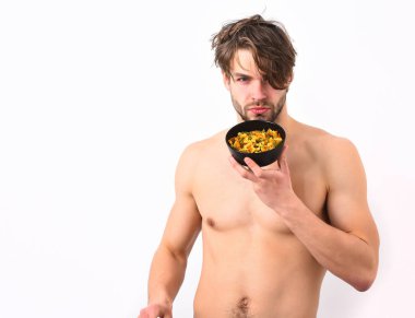 Kafkas seksi genç maço elinde makarna ile siyah kase tutuyor.