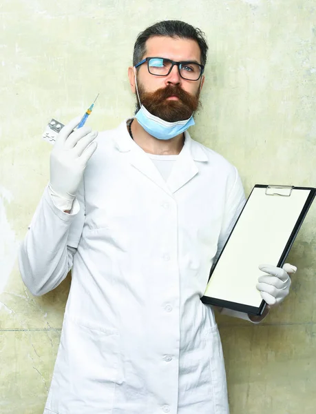 Barbudo brutal médico caucásico o estudiante de posgrado sujetando portapapeles — Foto de Stock