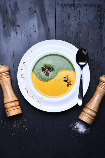 Zuppa di spinaci e crema di zucca con scatola di peperoni e saliera — Foto Stock