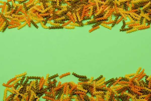 Красочные макароны Фузилли на зеленом фоне — стоковое фото