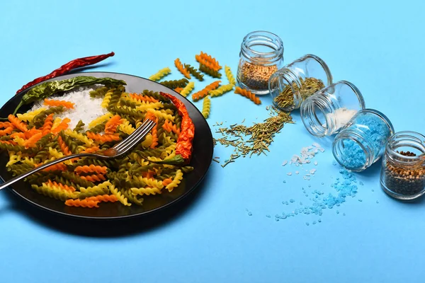 Salt, kryddor och örter spills från burkar och torkade fusilli — Stockfoto