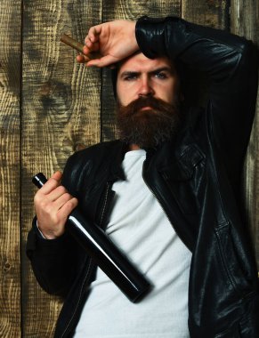 Sakallı, Kafkas hippisi elinde şişe, puro içiyor.