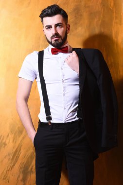 Stüdyo duvarında ciddi bir yüzü olan sakallı bir adam.