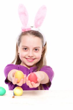 Paskalya yumurtalarını beyaza saklayan küçük mutlu bir kız bebek.