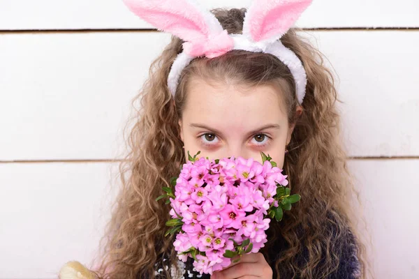 Gelukkig meisje in paashaas oren met roze bloem boeket — Stockfoto