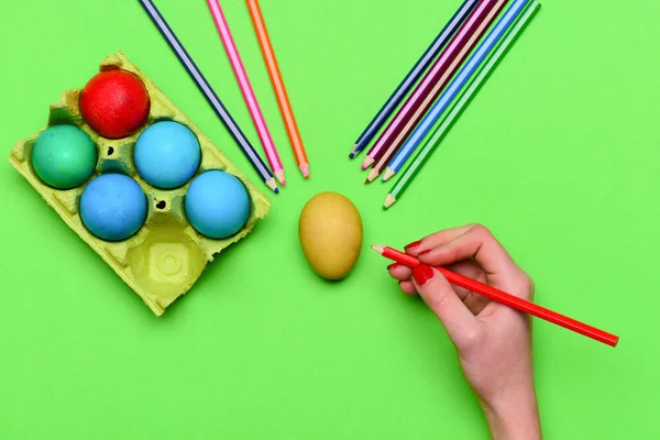 Mãos femininas com ovos de páscoa pintados coloridos com lápis — Fotografia de Stock
