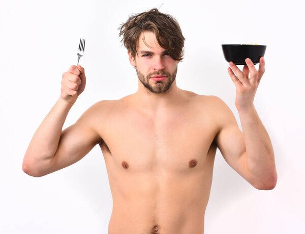 Caucasian sexy young macho holding black bowl with fork