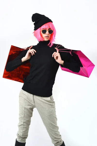 Modische sexy Mädchen in rosa Perücke mit Verpackung oder Taschen — Stockfoto