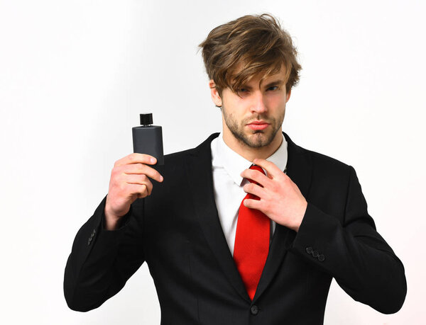 Кавказский стильный бизнесмен позирует с духами