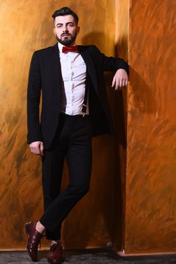 Stüdyo duvarında ciddi bir yüzü olan sakallı bir adam.