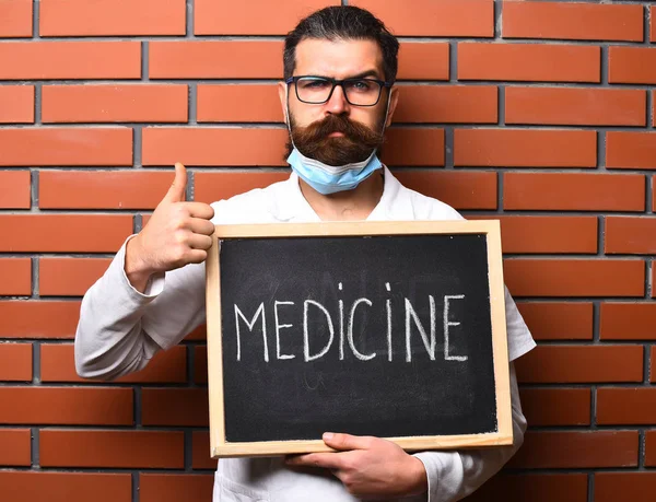 Бородатий жорстокий кавказький лікар тримає дошку з написом "Медицина" — стокове фото