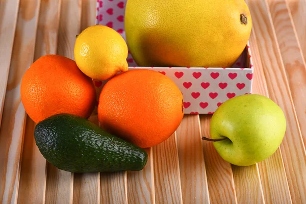 Vários frutos: limão, maçã, laranja, abacate na mesa de madeira — Fotografia de Stock