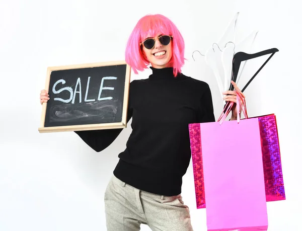 Mädchen in Perückenpackung, Kleiderbügel, Tafel mit Verkaufsaufschrift — Stockfoto