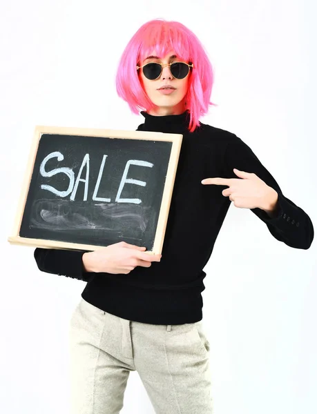 头戴假发的时髦女孩，手持刻有销售字样的木板 — 图库照片
