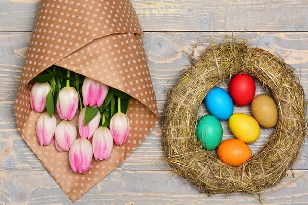 Yuvadaki renkli paskalya yumurtaları, pembe güzel laleler, anneler günü. — Stok fotoğraf