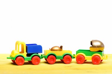 altın yumurta içinde oyuncak kamyon araba üzerinde kırık deniz hayvanı kabuğu