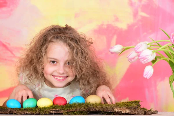 Feliz chica de Pascua con coloridos huevos y flores de tulipán — Foto de Stock