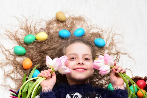 Glad påsk flicka, färgglada ägg i långt hår, tulpan blommor — Stockfoto