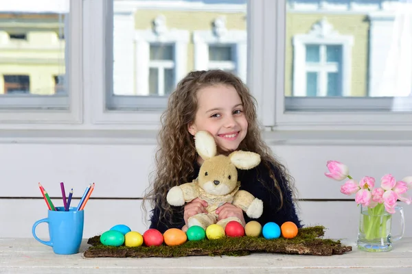 Boldog lány nyúl játék, ceruza, tulipán virágok, húsvéti tojás — Stock Fotó