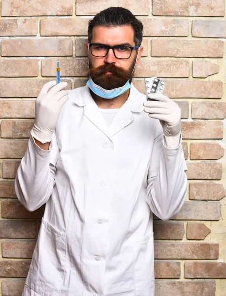 Γενειοφόρος βάναυσος καυκάσιος γιατρός ή μεταπτυχιακός φοιτητής κρατώντας χάπια — Φωτογραφία Αρχείου