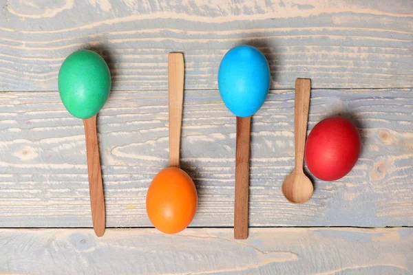 Menu design, easter food, colorful painted eggs in wooden spoons — Stock Photo, Image