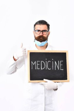 Sakallı beyaz doktor elinde şırınga ve ilaç yazısıyla geziyor.