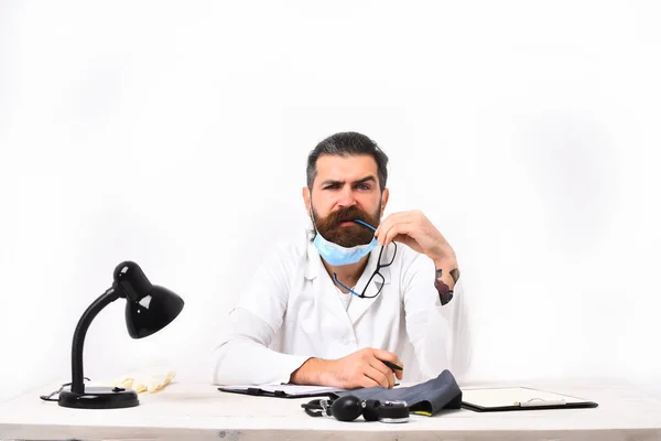 Médico caucásico barbudo sentado en la mesa — Foto de Stock