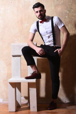 Stüdyo duvarında ciddi bir yüzü olan sakallı bir adam.