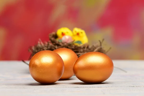 Великодні золоті яйця і жовта курка, курячі птахи в гнізді — стокове фото