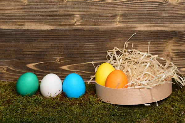 Huevos coloridos de Pascua pintados en caja de madera sobre fondo de madera —  Fotos de Stock