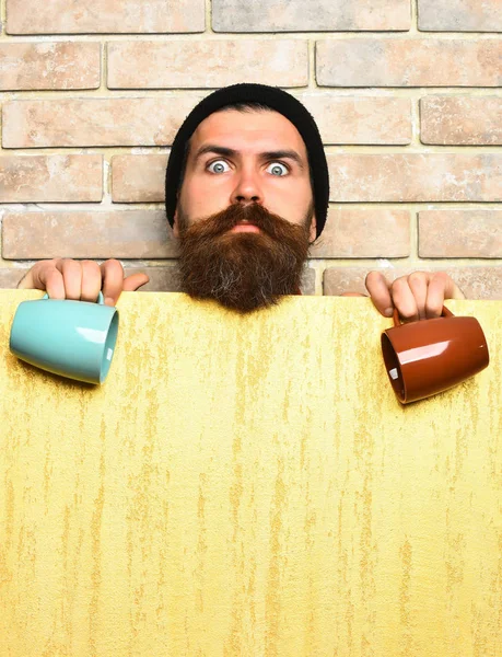 Barbudo brutal hipster caucásico con hoja de papel y tazas —  Fotos de Stock