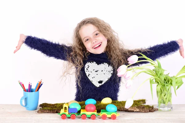 Feliz chica de Pascua con huevos de colores en camiones, lápices, tulipanes — Foto de Stock