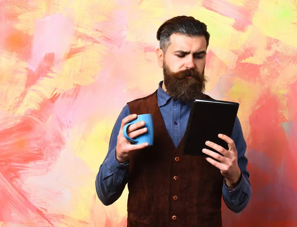 Barbuto brutale hipster caucasico con tazza di caffè e notebook nero — Foto Stock