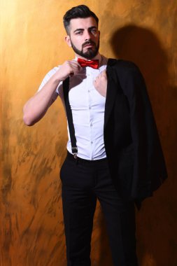 Stüdyo duvarında ciddi bir yüzü olan sakallı bir adam.