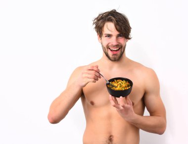 Kafkas seksi genç maço elinde makarna ile siyah kase tutuyor.