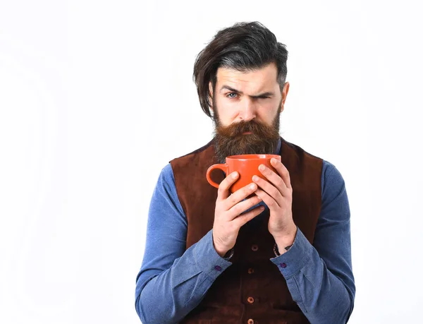 Бородатый мужчина держит чашку кофе, чай с серьезным лицом — стоковое фото