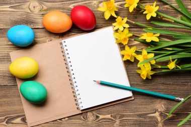 Renkli yumurtalar, sarı narsis, çizim için kağıt defter ve kalem.