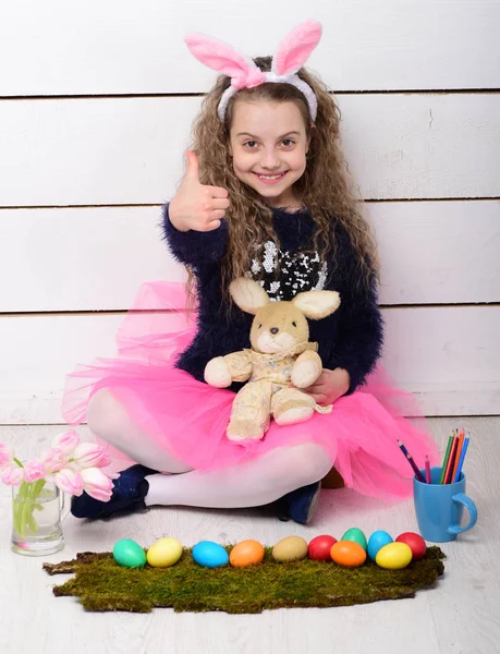 Chica feliz con juguete de conejo de Pascua, lápiz, flores de tulipán, huevos — Foto de Stock