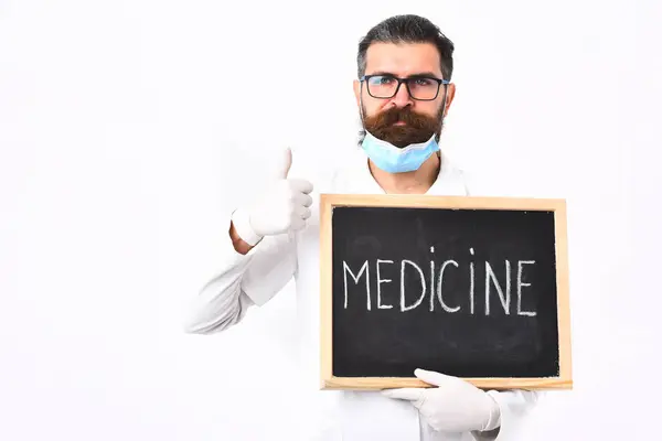 Médico caucasiano barbudo segurando seringa e papelão com inscrição em Medicina — Fotografia de Stock