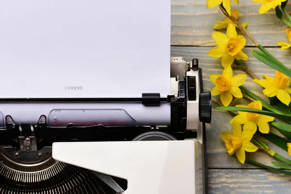 Vecchia macchina da scrivere vintage con carta e fiori di narciso in fiore primaverile — Foto Stock