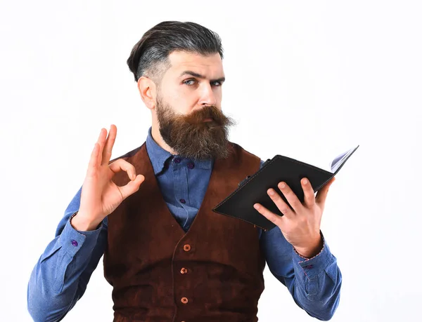 Бородатый мужчина держит блокнот с серьезным лицом — стоковое фото