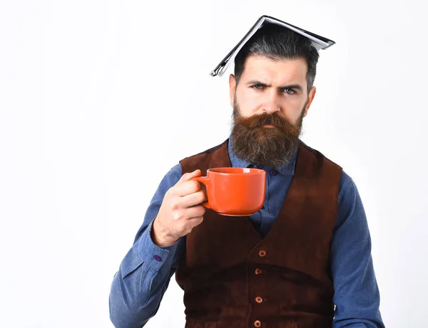 Бородатый мужчина держит блокнот, чашку чая с серьезным лицом — стоковое фото