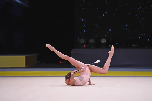 Гимнастка выступает на соревнованиях по художественной гимнастике — стоковое фото