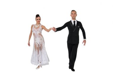 Dans eden balo çifti beyaz sahilde yalnız poz veriyor.