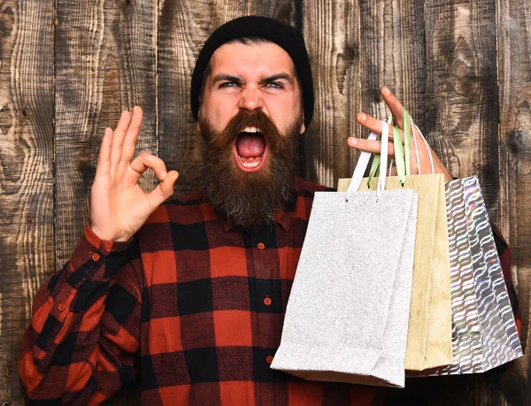 Barbudo brutal caucasiano hipster com bigode segurando pacotes de compras — Fotografia de Stock