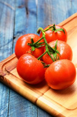 Asma, mavi vintage ahşap arka plan domates. Sağlıklı ve Pazar kavramı