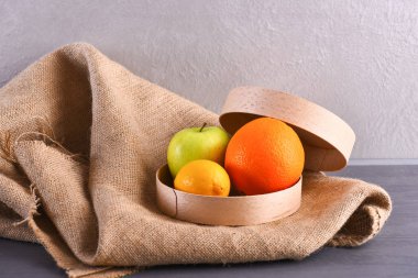 çeşitli meyve: limon, elma, portakal çul peçete üzerinde